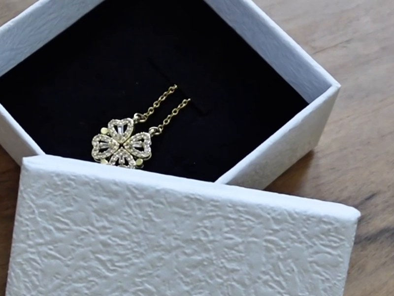 The clover necklace in its open gift box
