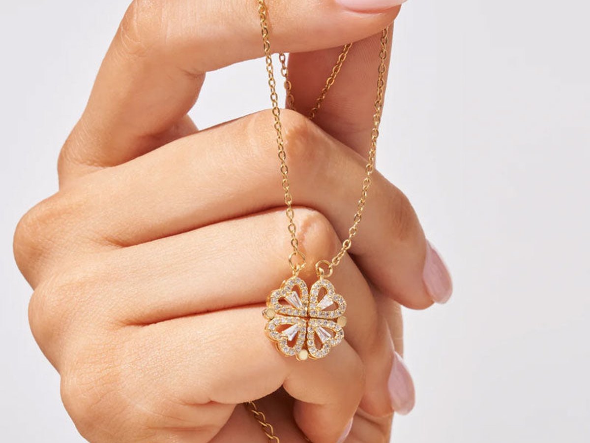 Fingers holding the Clover Heart pendant in its clover shape